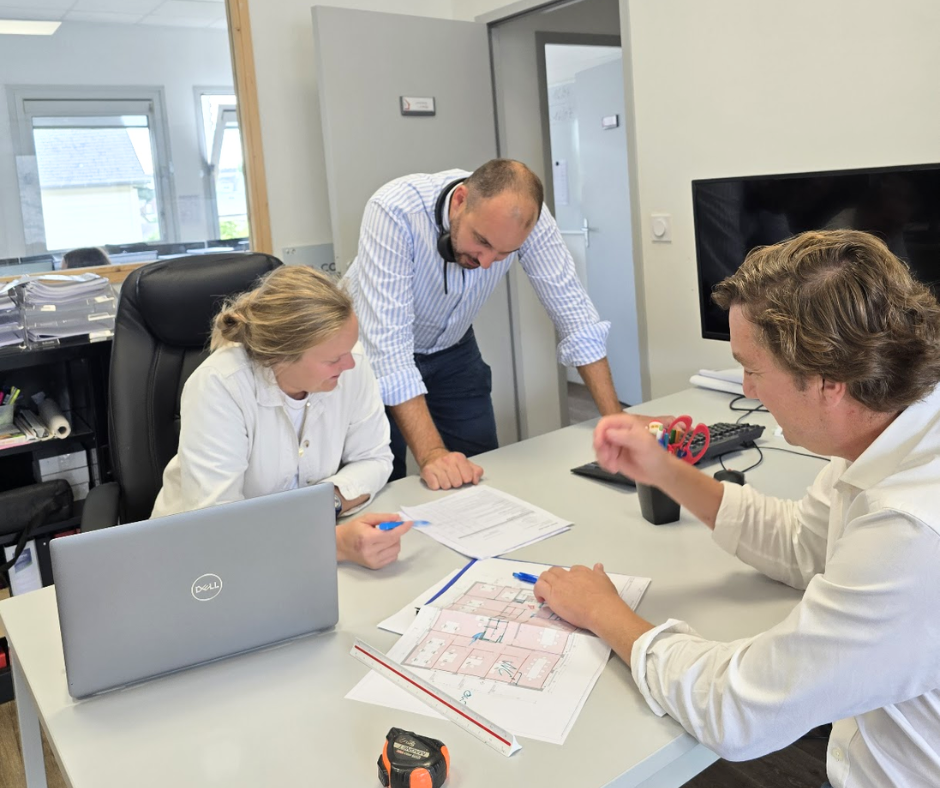 Équipe TFL GROUPE, MBC ARCHITECTURE et TFL MAÎTRISE D'ŒUVRE en réunion autour des plans d'un projet d'architecture et de maîtrise d'œuvre en Mayenne, réunissant les compétences nécessaires à la conception et à la coordination du chantier.